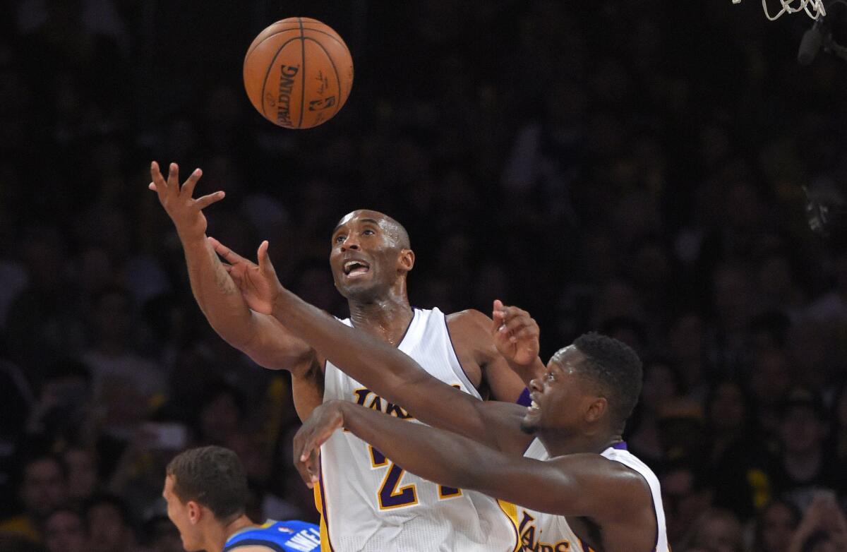 Lakers guard Kobe Bryant, left, and forward Julius Randle go after a rebound during a loss to the Dallas Mavericks.
