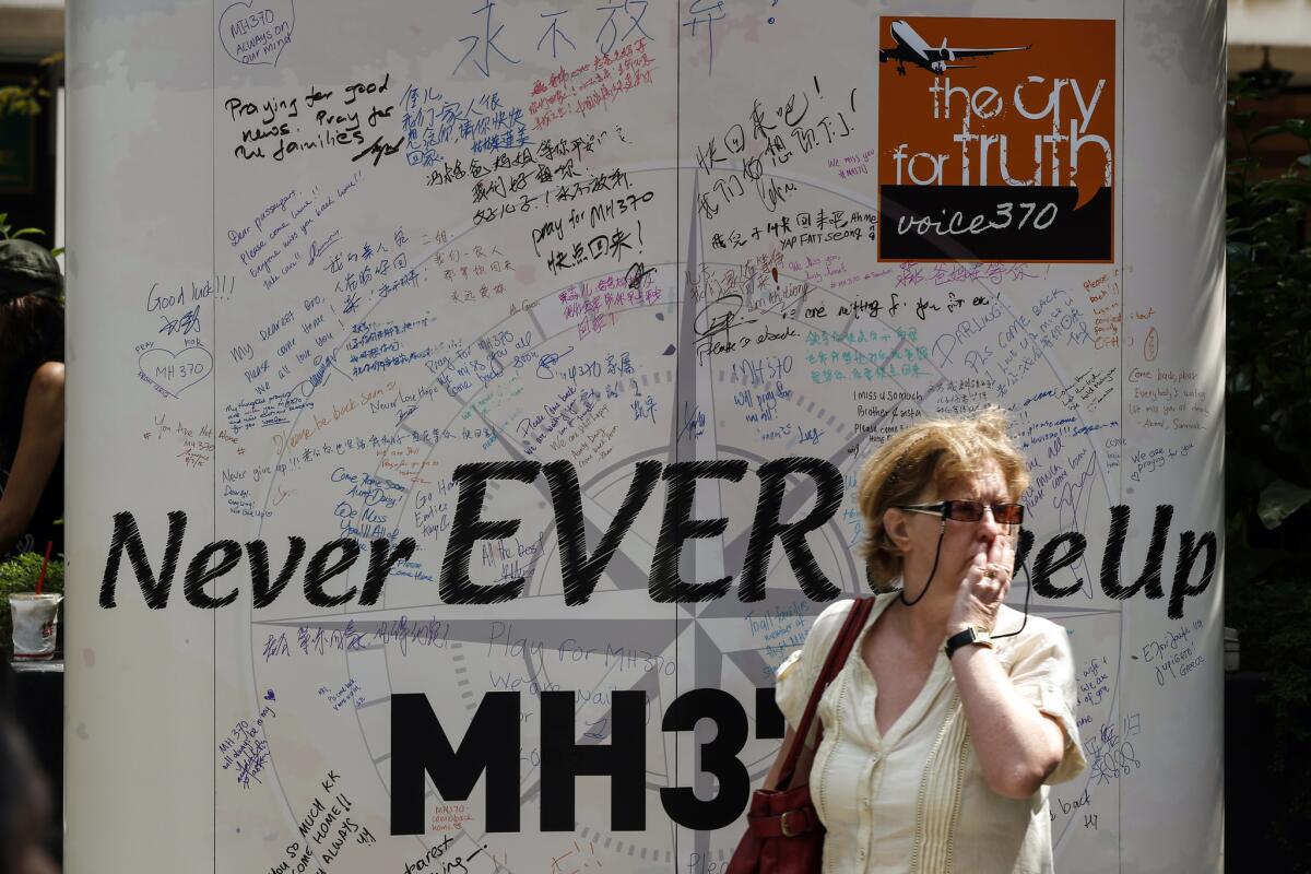 A visitor walks past a board with well-wishing messages during a remembrance event for the missing Malaysian fliight 370 on March 8 in a mall outside Kuala Lumpur, Malaysia. The FAA has called for a study on the mental and emotional health of commercial pilots.