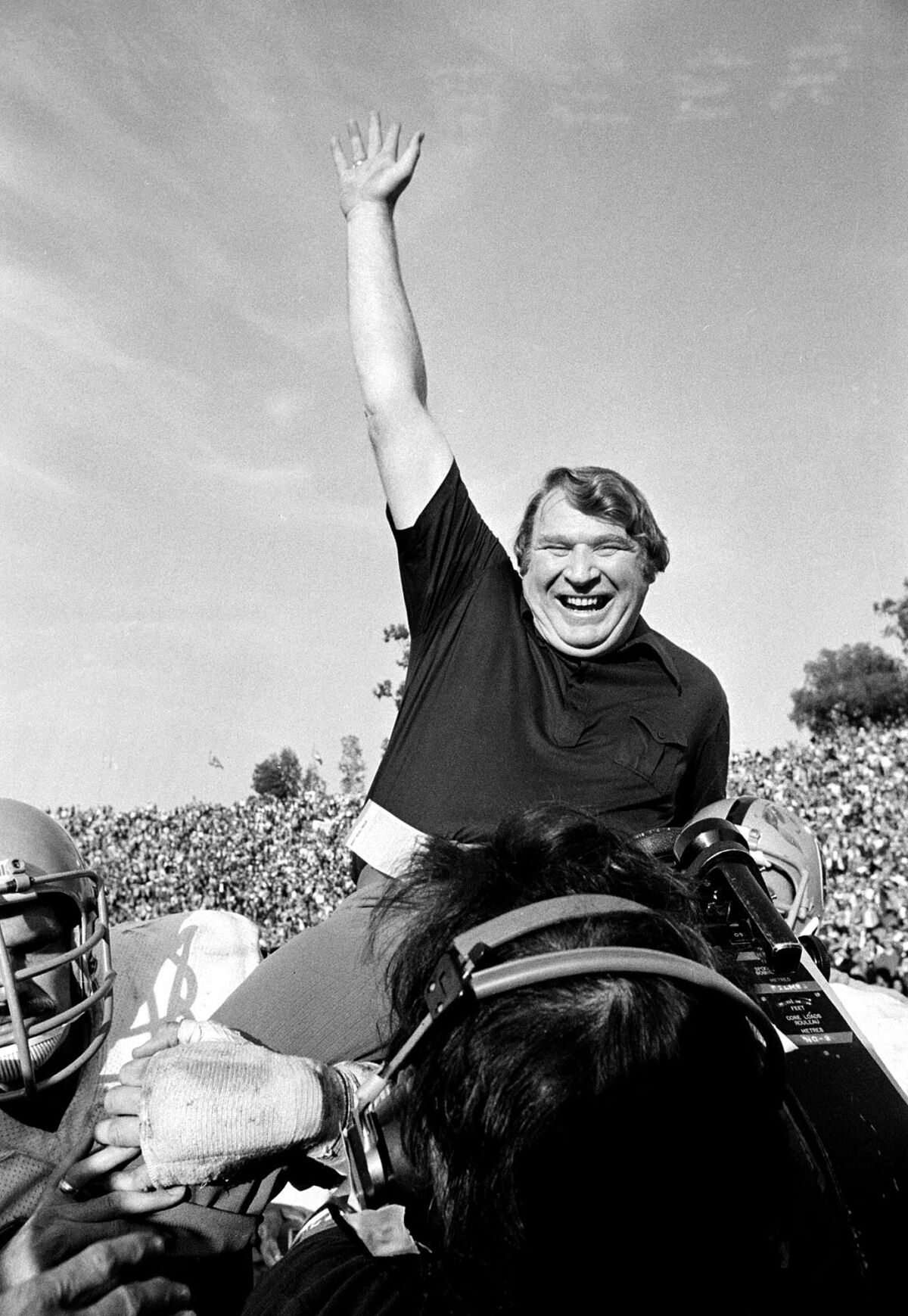 Raiders head coach John Madden is carried from the field by his players.