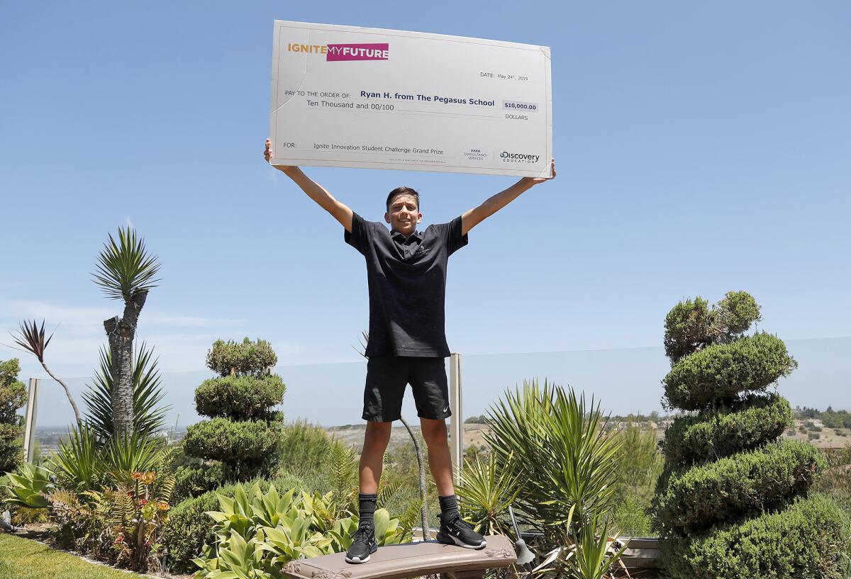 Ryan Honary holds up his check for winning the Ignite Innovation Student Challenge in 2019. 