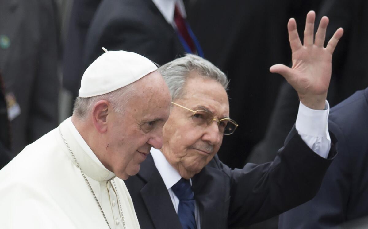 Cuba's President Raul Castro waves as he escorts Pope Francis during the pope's arrival ceremony at the airport in Havana. Pope Francis began a 10-day trip to Cuba and the United States on Saturday.