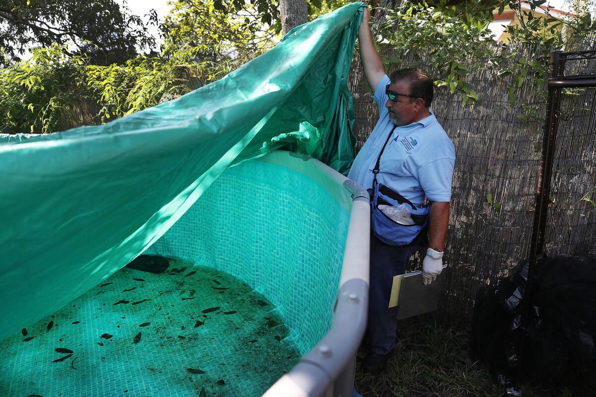 Robert Muxo, a Miami-Dade County mosquito control inspector, inspects a property for mosquitoes or breeding areas in the Wynwood neighborhood Saturday as the county fights to control the Zika virus outbreak.