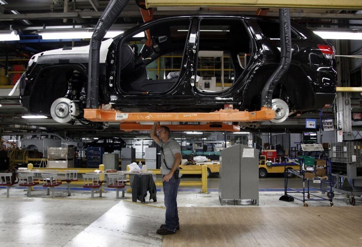 U.S. economic growth accelerated in the second quarter. Above, a worker checks a vehicle at a Chrysler factory in Detroit.