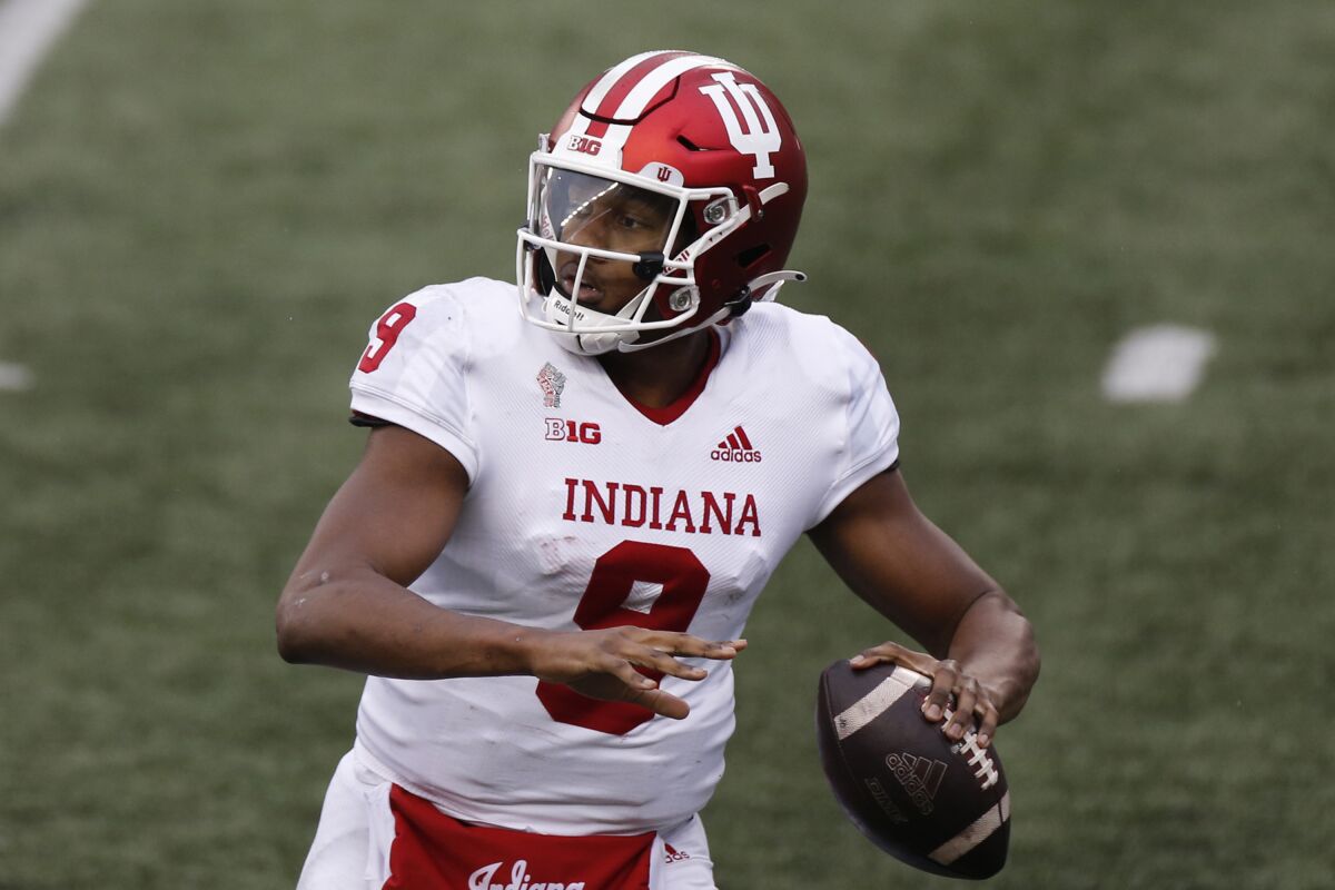 FILE - Indiana quarterback Michael Penix Jr. plays against Ohio State during an NCAA college football game in Columbus, Ohio, in this Saturday, Nov. 21, 2020, file photo. Penix watched his teammates finish the last three seasons without him. On Saturday, Sept., 4, 2021, he's expected to return to the field after a second knee surgery when the 17th-ranked Hoosiers open the season at Iowa.(AP Photo/Jay LaPrete, File)