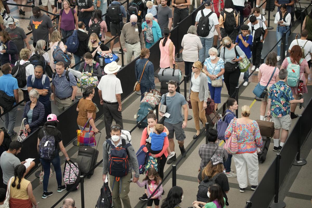 Viajeros se forman para pasar un control de seguridad en el Aeropuerto Internacional de Denver, 