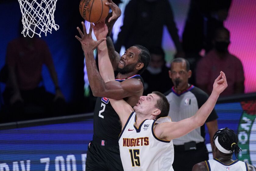 Los Angeles Clippers forward Kawhi Leonard (2) grabs a rebound over Denver Nuggets center Nikola Jokic (15) during the first half of an NBA conference semifinal playoff basketball game Tuesday, Sept. 15, 2020, in Lake Buena Vista, Fla. (AP Photo/Mark J. Terrill)