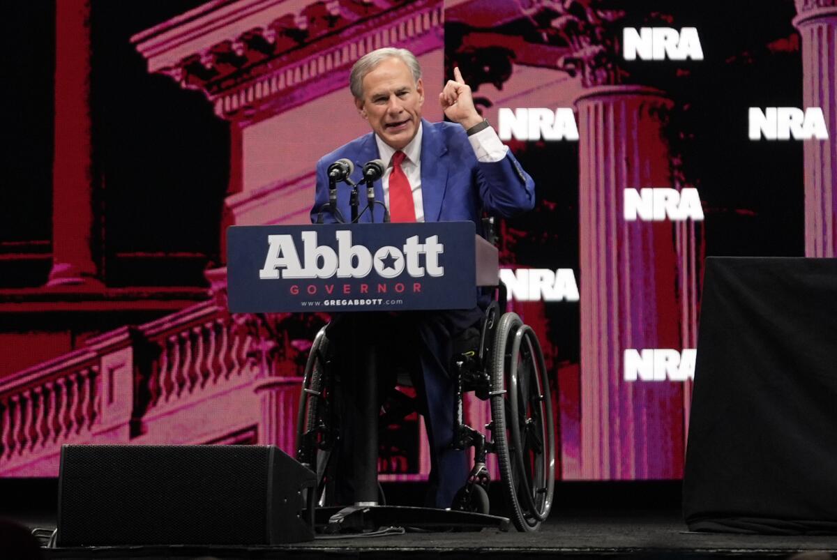 Greg Abbott speaks in front of an NRA backdrop