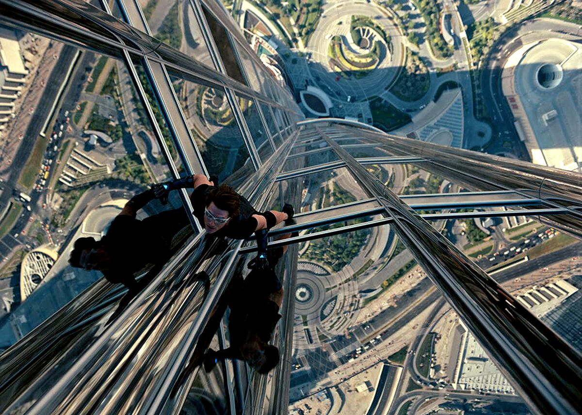 Tom Cruise scales the side of a glass skytower