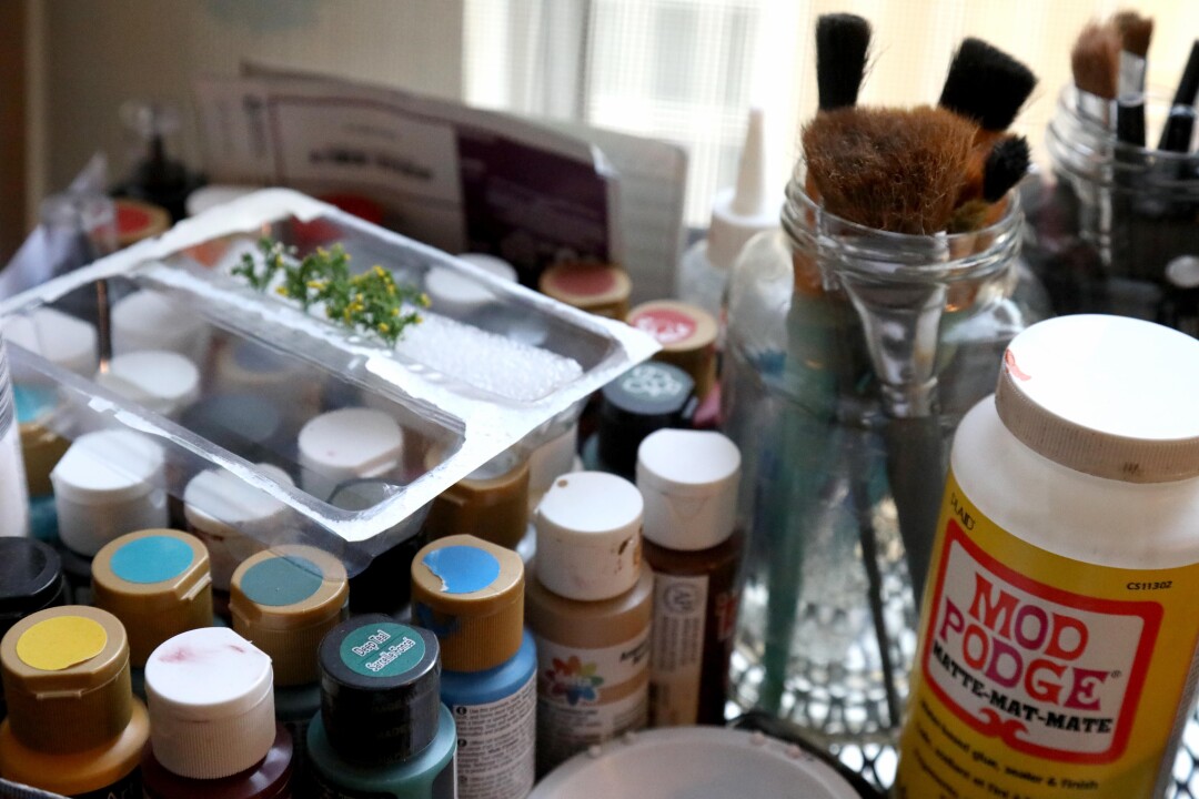 Paints, brushes and other materials that Kieran Wright uses to make his miniature creations of classic Los Angeles buildings.