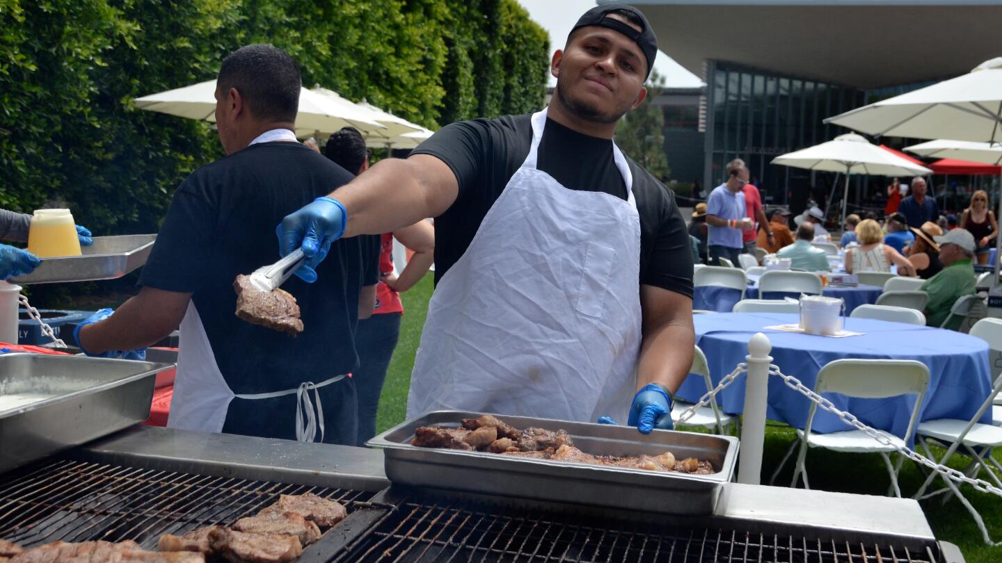 Alan Ortiz grills New York strip steaks during Sunday's Lobsterfest in Newport Beach.