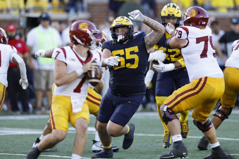 Michigan defensive lineman Mason Graham pushes past the USC offensive line and moves toward Trojans QB Miller Moss