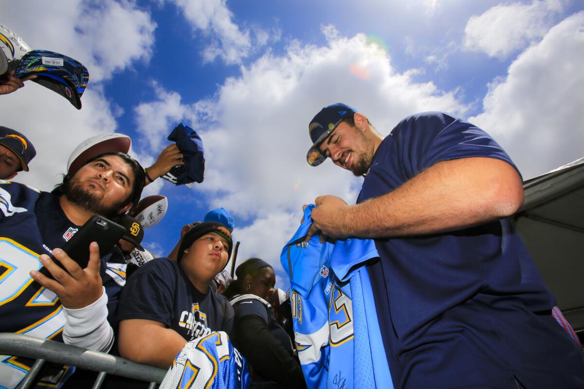 Max Tuerk signs autographs for Chargers fans during an event at Qualcomm Stadium in 2016.
