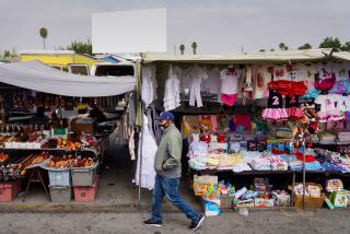 PARAMOUNT, CA - JUNE 27: People walk past vendors at the Paramount Swap Meet on Saturday, June 27, 2020 in Paramount, CA. Swap Meets across the Southland are struggling to bounce back after finally re-opening amid the ongoing Coronavirus pandemic. (Kent Nishimura / Los Angeles Times)