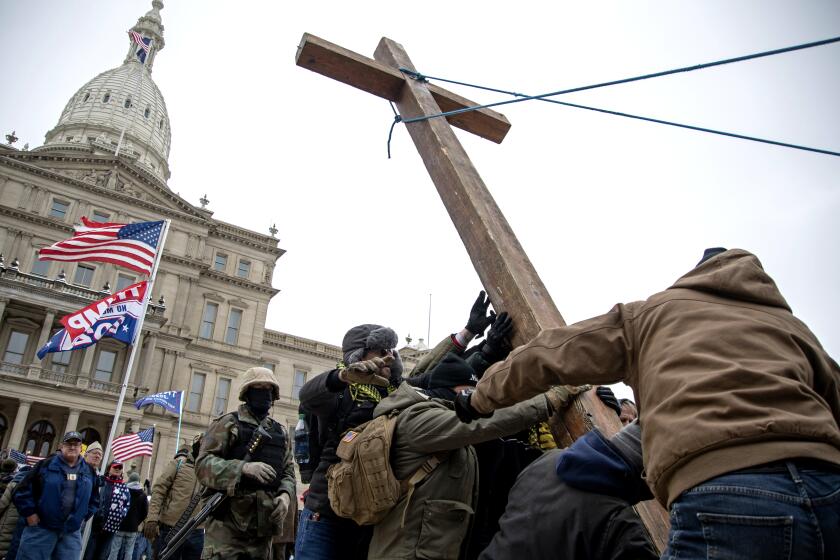 Members of the Proud Boys raise a cross on January 6, 2021 at the Michigan State Capitol in Lansing, Michigan, where a few hundred Trump supporters gathered to peacefully protest the certification of electoral votes by the United State Congress as Washington D.C. fell into chaos with Trump supporters storming the U.S. Capitol Building. (Photo by Adam J. Dewey/NurPhoto via AP)