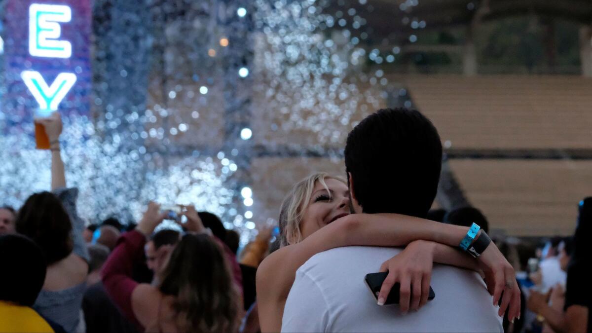 A couple embrace during the Classic West festival at Dodger Stadium in Los Angeles on Sunday.