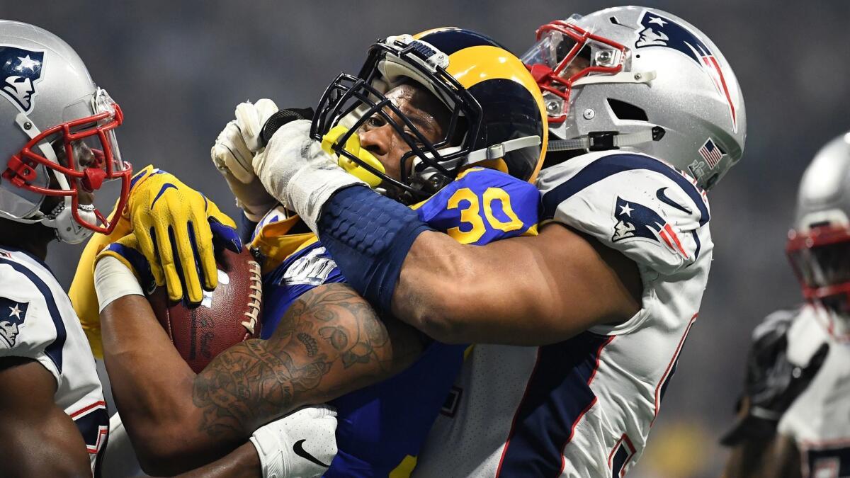 Rams running back Todd Gurley is stopped for a short gain by Patriots defenders Deatrich Wise Jr., right, and Jason McCourty during the third quarter.