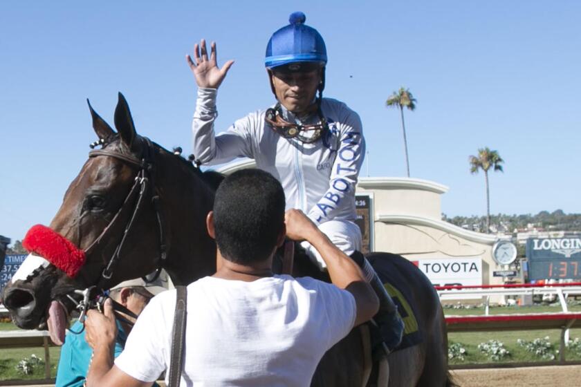 Groom Raul Aguilar congratulates jockey Abel Cedillo after Cedillo rode horse "Two Thirty Five" to victory in the sixth race of the day at Del Mar on August 21, 2019.