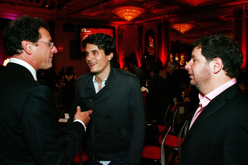 Three men chat at a formal event