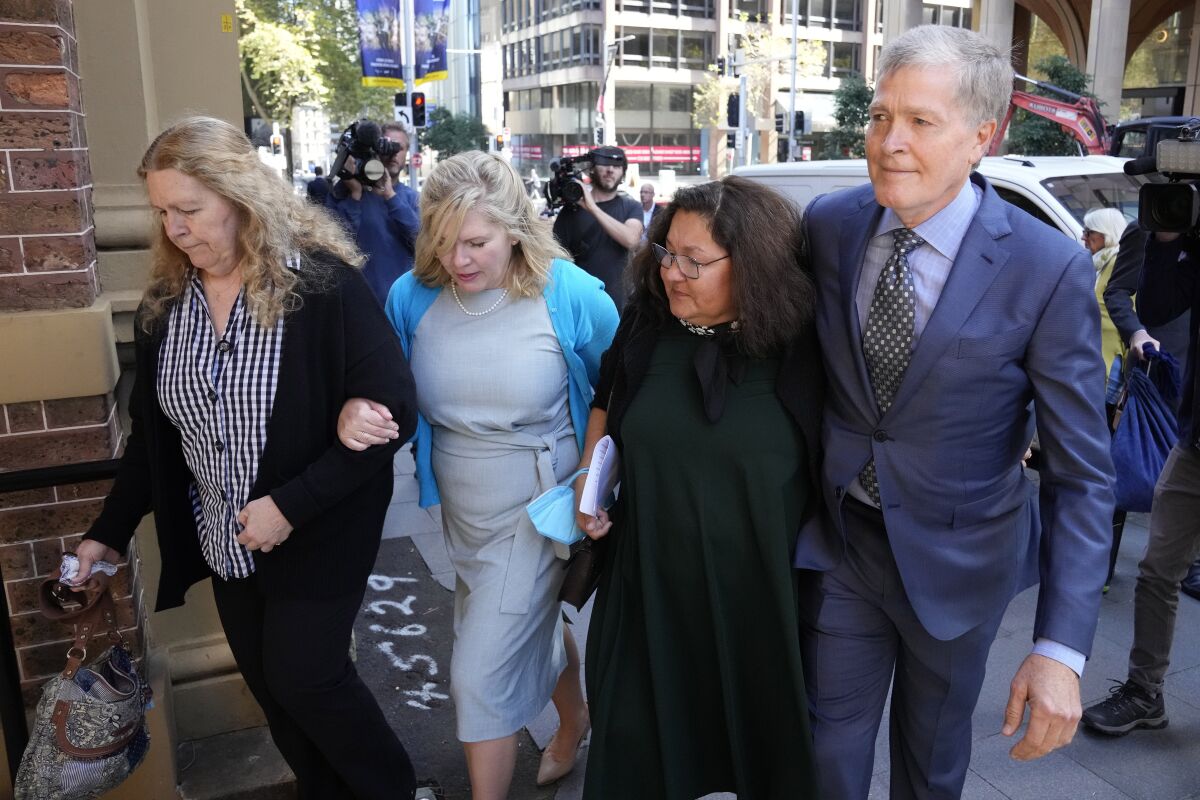 Steve Johnson, right, with his sisters, Terry, left, and Rebecca and his wife Rosemarie, second right, arrive at the Supreme Court in Sydney, Monday, May 2, 2022, for a sentencing hearing in the murder of Scott Johnson, Steve, Terry and Rebecca's brother. Scott White appeared in the New South Wales state Supreme Court for a sentencing hearing after he pleaded guilty in January to the murder of the Los Angeles-born Canberra resident Scott Johnson, whose death at the base of a North Head cliff was initially dismissed by police as suicide. (AP Photo/Rick Rycroft)
