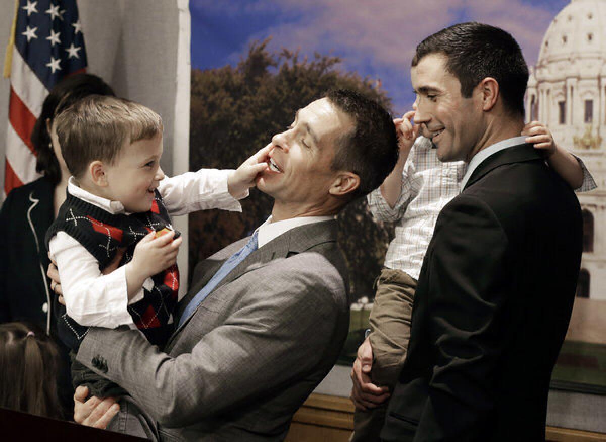 Dr. Paul Melchert, left, with his son, Emmett, as he attempts to address the media while his partner James Zimerman, right, holds twin, Gabriel, during a news conference in St. Paul, Minn., where lawmakers introduced a bill to legalize gay marriage in Minnesota. On Thursday the American Academy of Pediatrics, the most influential U.S. pediatricians' group, endorsed gay marriage, saying a stable relationship between parents regardless of sexual orientation contributes to a child's health and well-being.