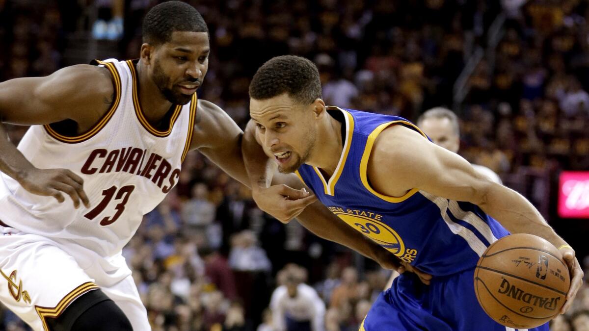 Warriors guard Stephen Curry (30) drives against Cavaliers center Tristan Thompson (13) during the first half of Game 4 on Friday night in Cleveland.