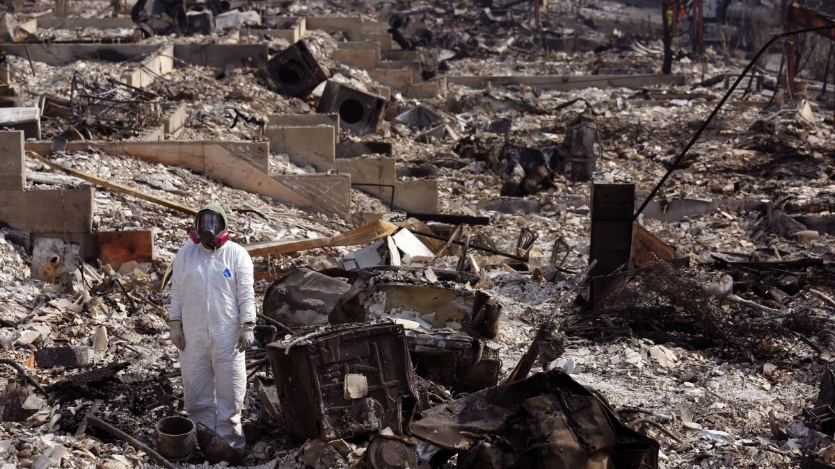 Alyssa Paris stands immobile while viewing the charred ruins of her mother's home in Wikiup, Calif., on Monday.