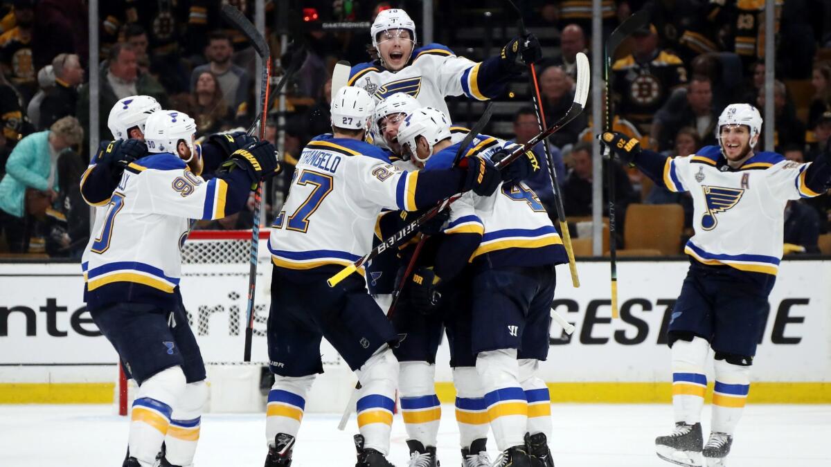 St. Louis Blues' Carl Gunnarsson (4) is congratulated by his teammates after scoring the game-winning goal during the first overtime period against the Boston Bruins in Game 2 of Stanley Cup Final on Wednesday in Boston.
