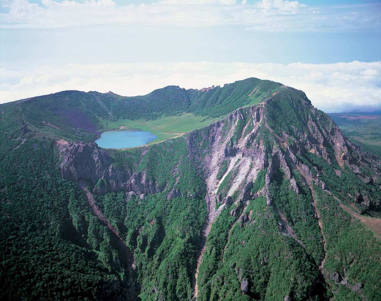 Year inscribed: 2007 Location: South Korea Jeju Island lies about 50 miles south of the Korean peninsula. The island comprises three noteworthy sites: Geomunoreum lava tubes, Seongsan Ilchulbong tuff cone and Mount Halla (pictured). UNESCO considers Geomunoreum the finest lava tube system in the world due to its multicolored and elaborate rock formations. The Seongsan Ilchulbong lava cone rises starkly from the ocean, making for an impressive sight. Mount Halla features waterfalls, rock formations and a lake-filled crater at its peak.