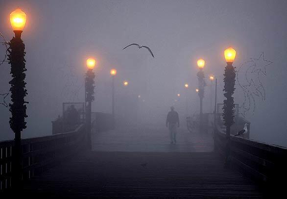 Ron Ringlien, of Seal Beach, walks the fog-shrouded Seal Beach pier. Ringlien, who walks the pier regularly, says he enjoys its beauty. "It's one of the best places in the world to live," he said.