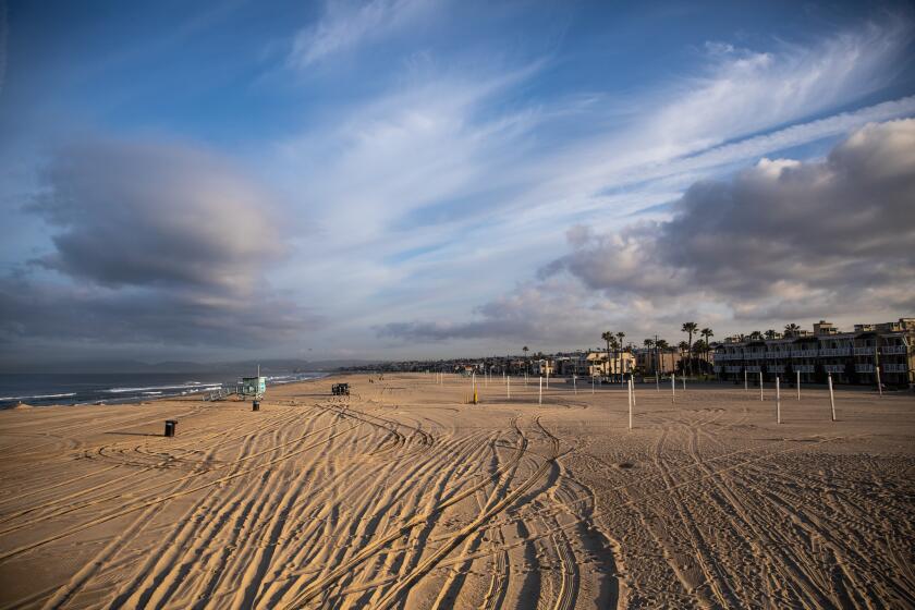 HERMOSA BEACH, CA --MARCH 28, 2020 - The Strand walking path and beach of Hermosa Beach, CA, are closed in an effort to prevent crowds and gatherings of people in the south bay town and slow the spread of the coronavirus, March 28, 2020. What began as only a city of Hermosa Beach, beach closure, quickly became a Los Angeles County beaches closure by late morning on Friday March 27, 2020, in an effort to slow the spread of the coronavirus. (Jay L. Clendenin / Los Angeles Times)