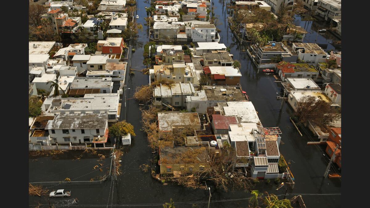 Hurricane Maria toppled electrical wires and trees and ripped roofs from some homes in San Juan, Puerto Rico's capital.