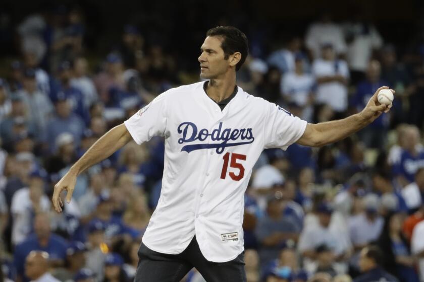 Los Angeles Dodgers' Shawn Green throws the ceremonial first pitch before Game 4 of the National League Championship Series baseball game against the Milwaukee Brewers Tuesday, Oct. 16, 2018, in Los Angeles. (AP Photo/Matt Slocum)