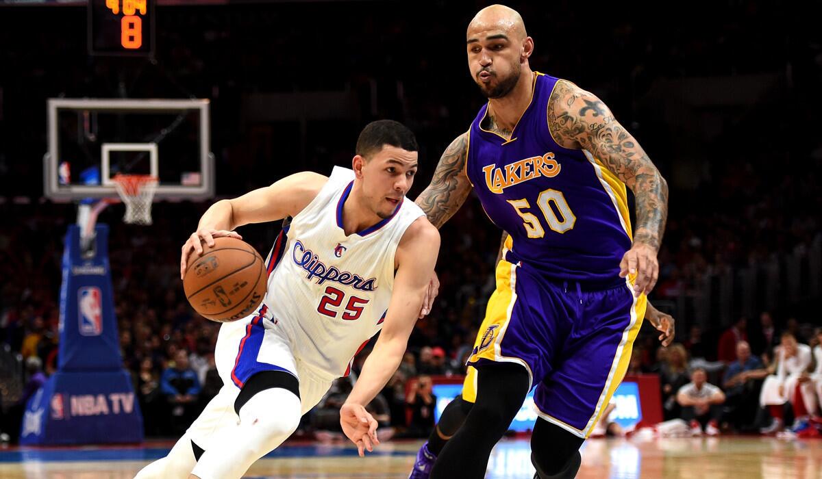 Clippers' Austin Rivers dribbles past Lakers' Robert Sacre during a 105-100 Clipper win at Staples Center on Tuesday.