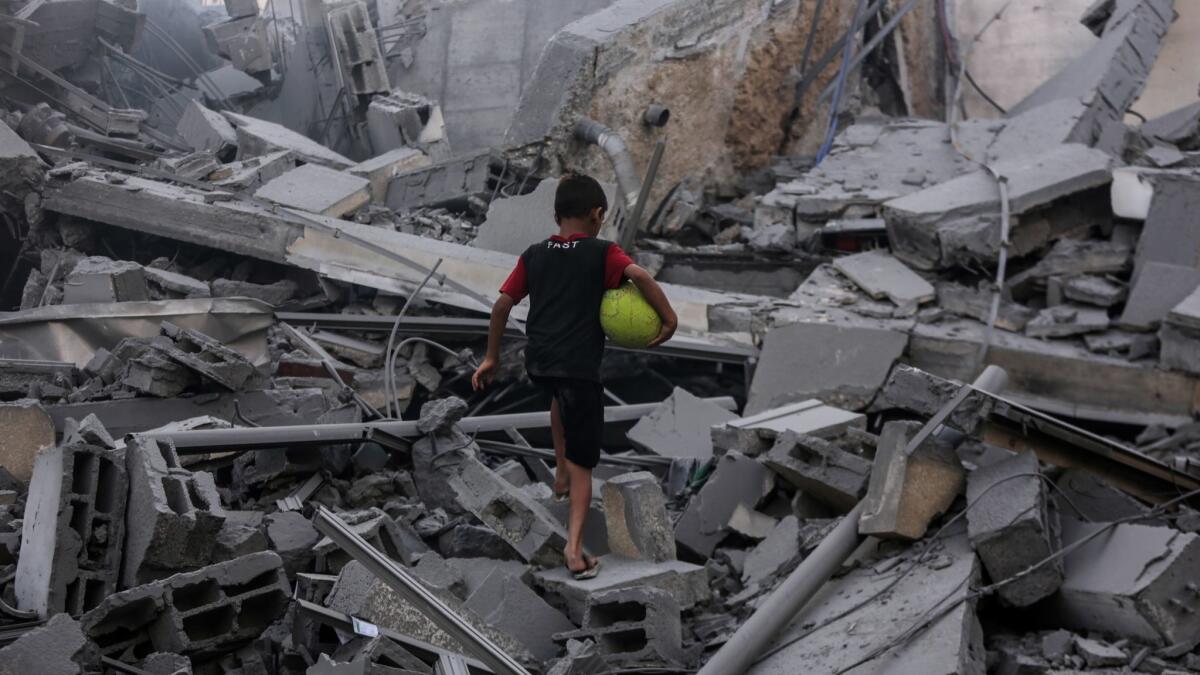 A child explores the rubble of the al-Meshal Cultural Center building destroyed in Israeli air strike in Gaza City.