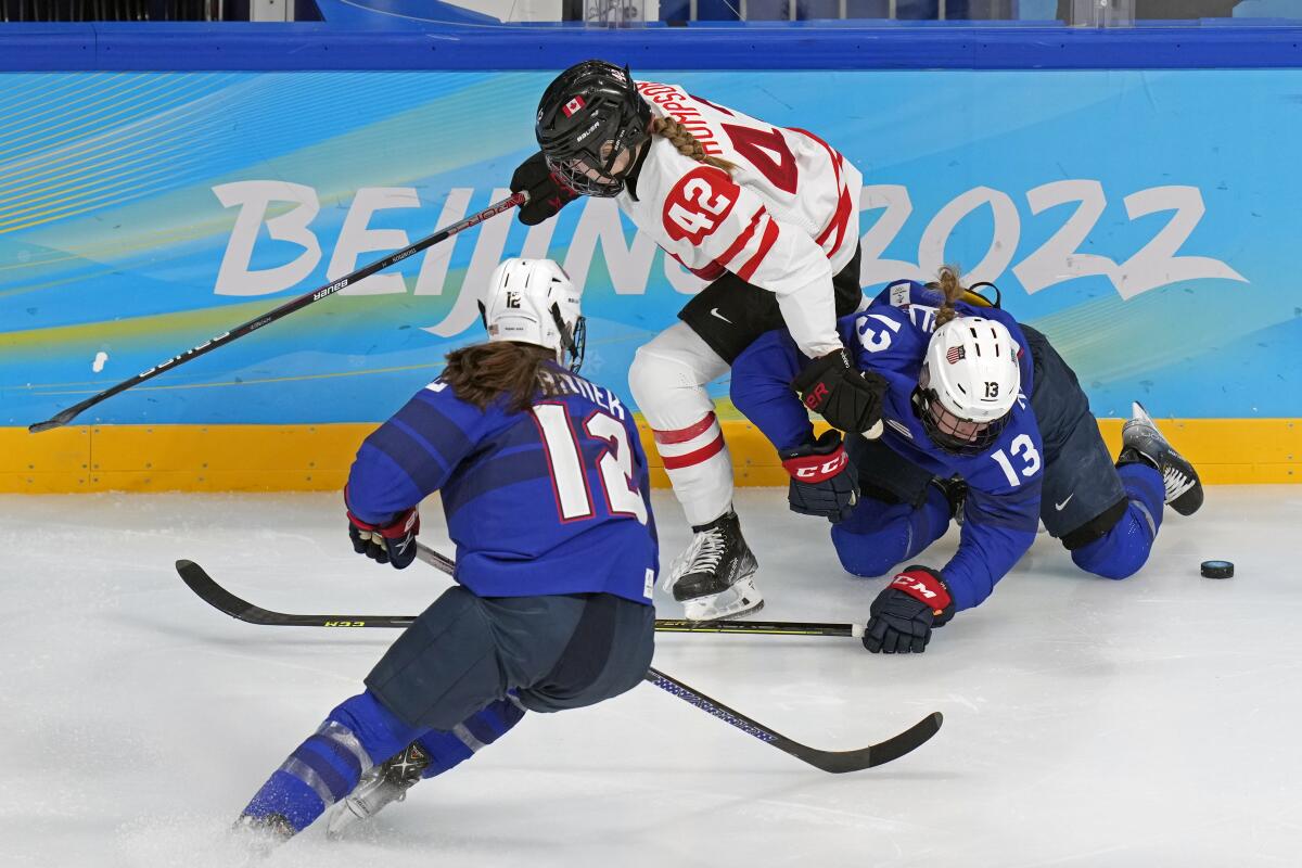 Canadian and U.S. hockey players battle at the 2022 Olympics.
