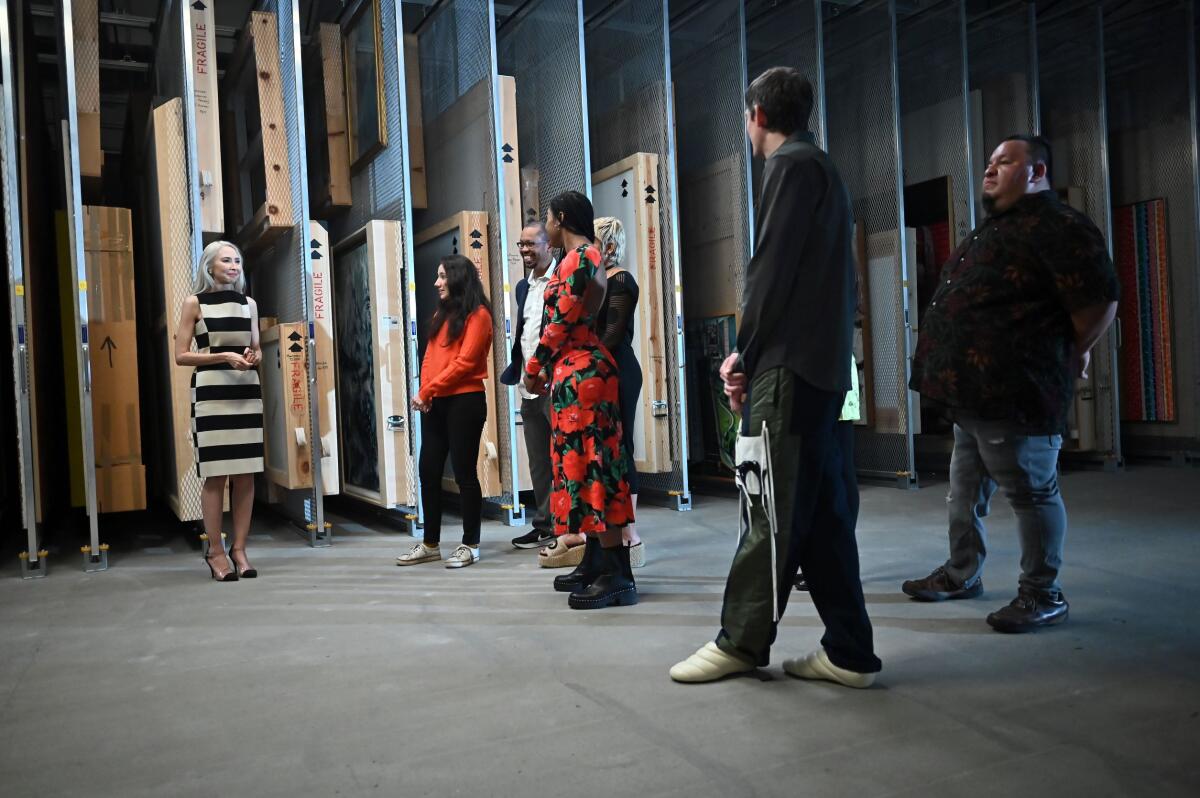 Artists stand in a museum's collection storage space.