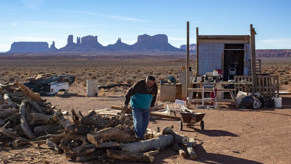Jonah Yellowman looks over firewood, gathered from Cedar Mesa, at his home on the edge of Monument Valley, Utah.