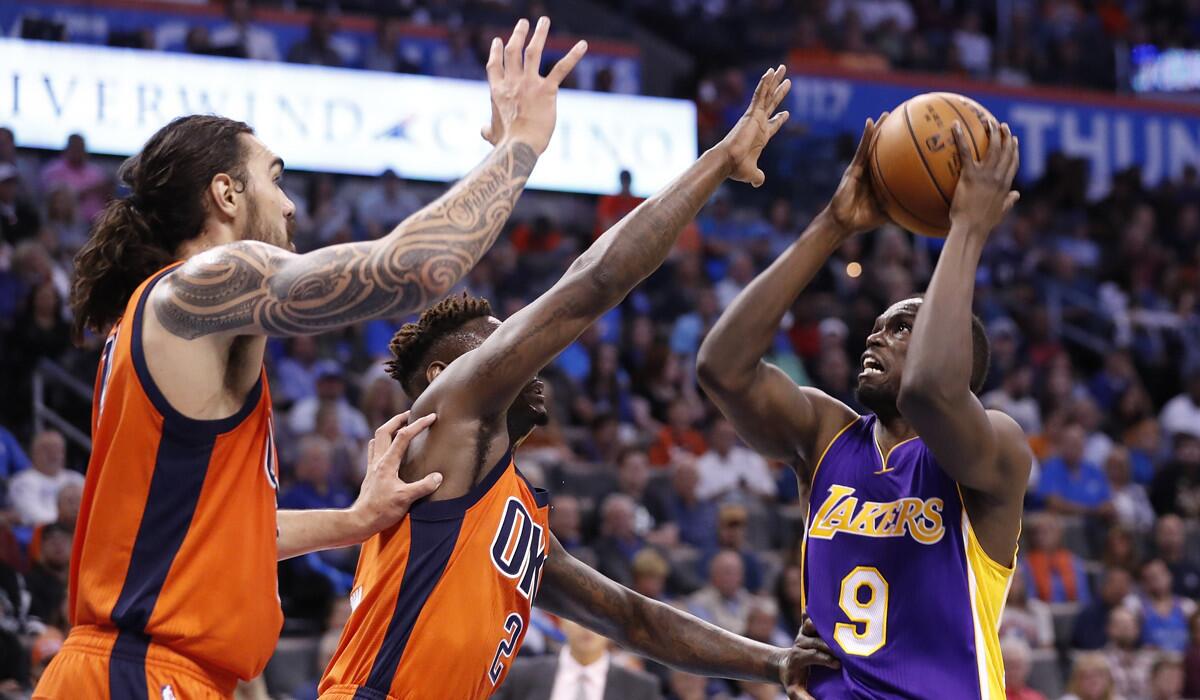 Lakers forward Luol Deng shoots as Thunder guard Anthony Morrow (2) and center Steven Adams (12) defend during their Oct. 30 game in Oklahoma City.