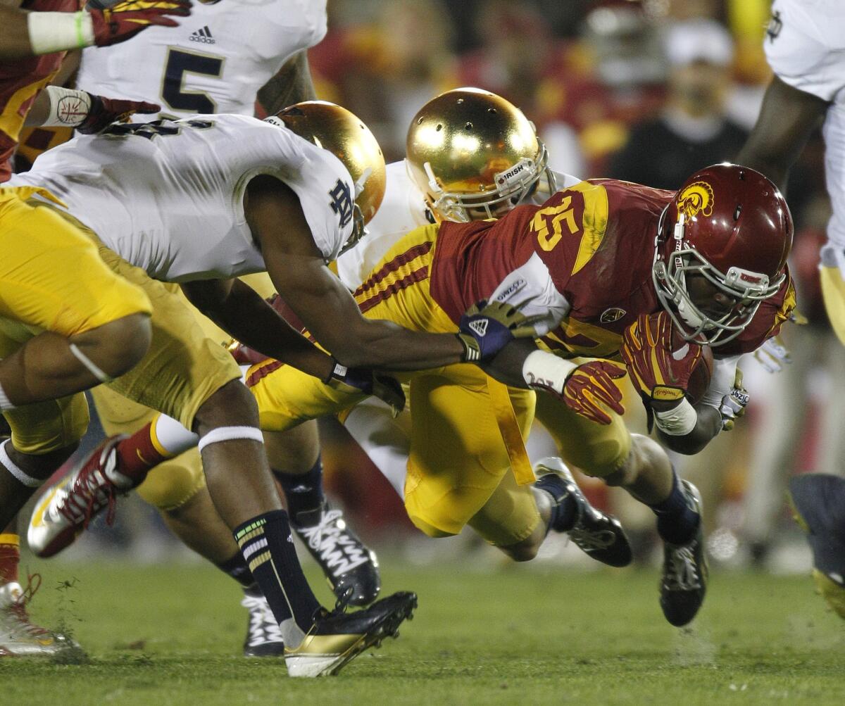 USC tailback Silas Redd is brought down by Notre Dame defenders after a gain last season at the Coliseum.