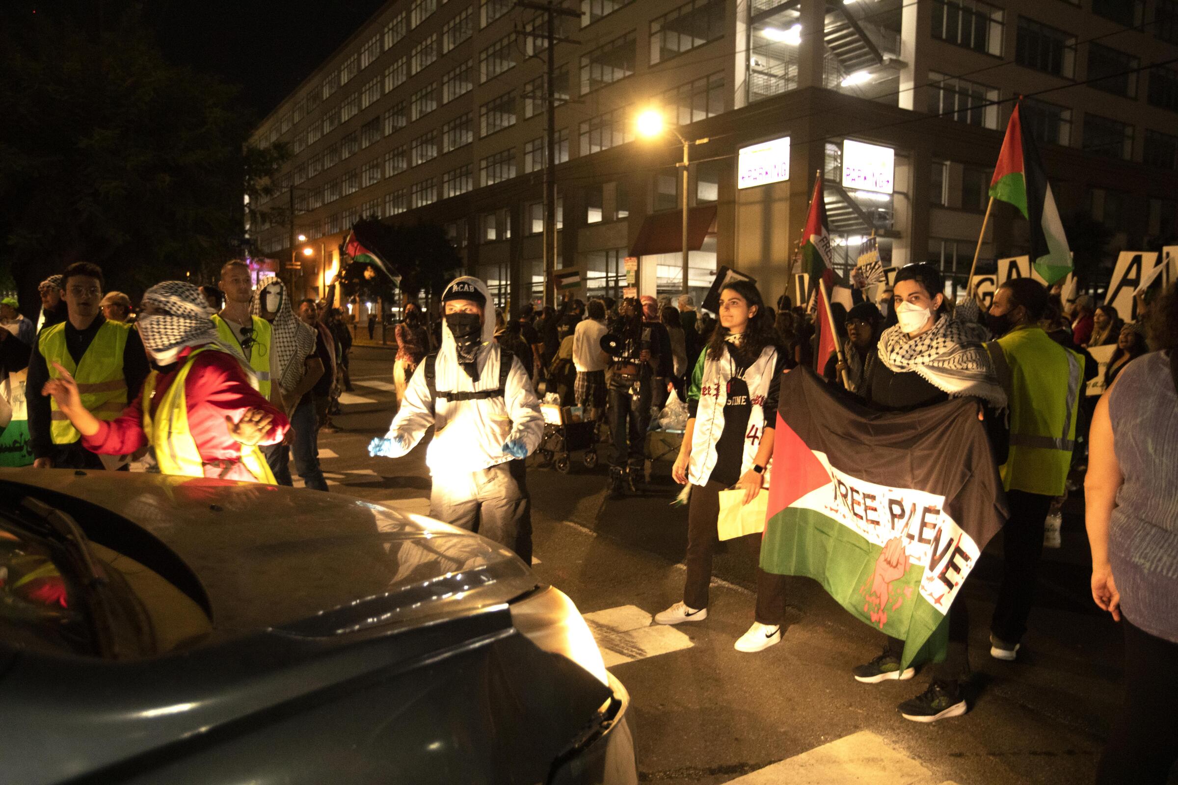 Protesters walk in traffic near LAX on Friday evening for a protest demanding a cease-fire in the Gaza Strip.
