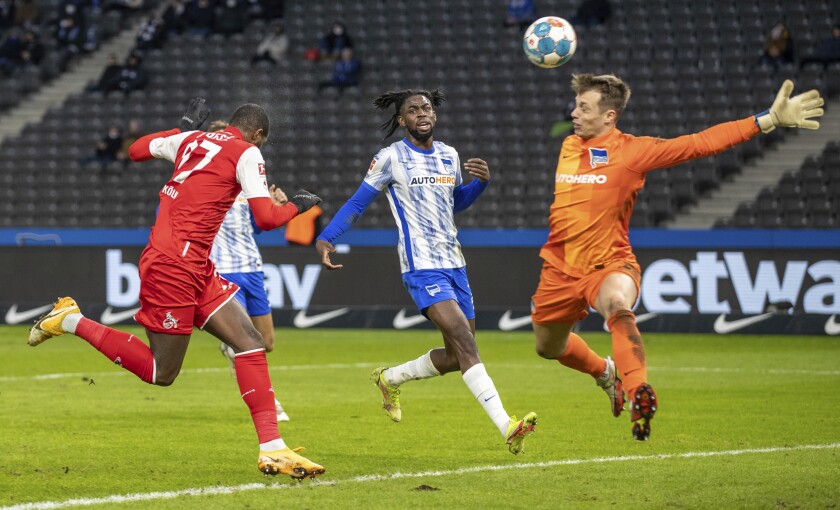 Cologne's Anthony Modeste, left, scores the opening goal during the German Bundesliga soccer match between Hertha BSC Berlin and 1. FC Cologne in Berlin, Germany, Sunday, Jan. 9, 2022. (Andreas Gora/dpa via AP)