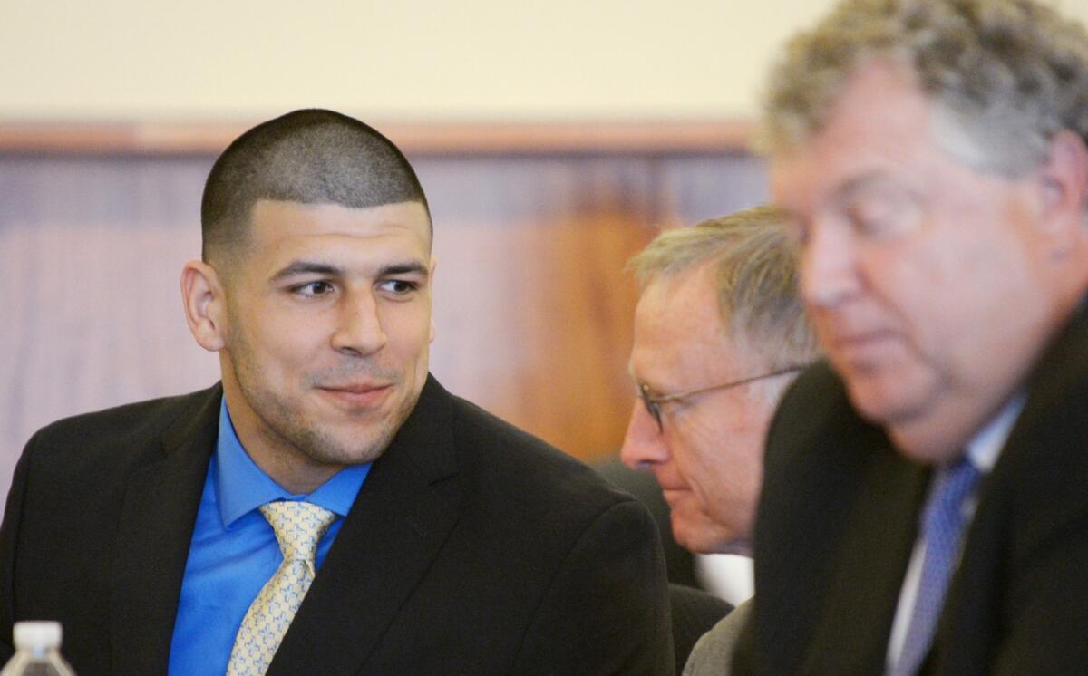 ORG XMIT: TOR630 Former NFL New England Patriots football player Aaron Hernandez talks with his defense attorney, Charles Rankin (C) during a hearing at the Bristol County Superior Court House in Fall River, Massachusetts, June 16, 2014. Attorneys for former NFL star Aaron Hernandez on Monday called on a judge to throw out charges that the ex-tight end murdered a semiprofessional football player in June 2013, one of three homicides Hernandez is charged with. REUTERS/Faith Ninivaggi/POOL (UNITED STATES - Tags: CRIME LAW SPORT)