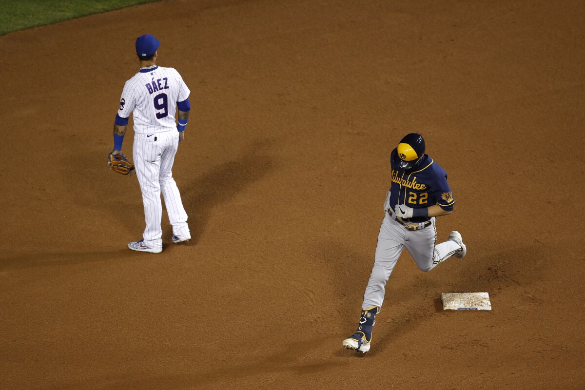 Milwaukee Brewers' Christian Yelich (22) rounds second base past Chicago Cubs shortstop Javier Baez (9) after hitting a three run home run during the sixth inning of a baseball game Friday, Aug. 14, 2020, in Chicago. (AP Photo/Jeff Haynes)