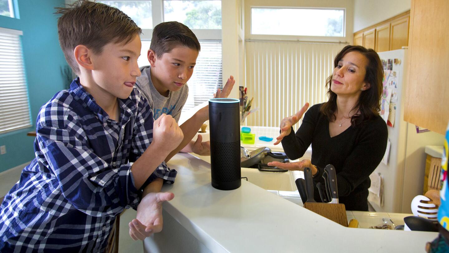 Liz Philips and her sons play rock-paper-scissors with "Alexa," their wireless speaker and voice command personal assistant.