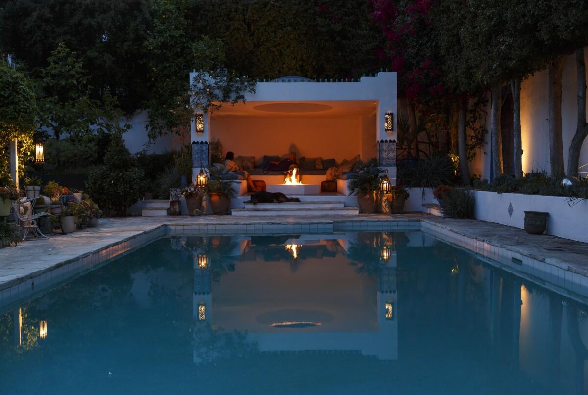 A lounge area next to this Los Angeles pool features a fireplace and Moroccan-inspired tiles and accents.