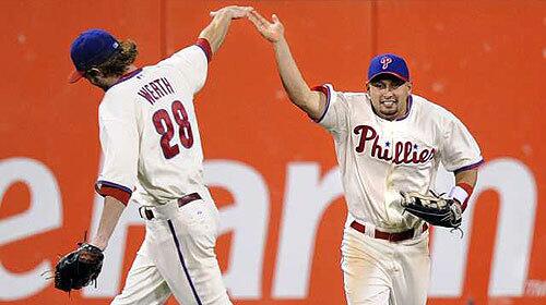 Phillies center fielder Shane Victorino is congratulated by right fielder Jayson Werth after making a leaping catch at the wall to rob Dodgers third baseman Casey Blake of an extra-base hit with two men on and two outs in the seventh inning of Game 2 of the NLCS on Friday night in Philadelphia.