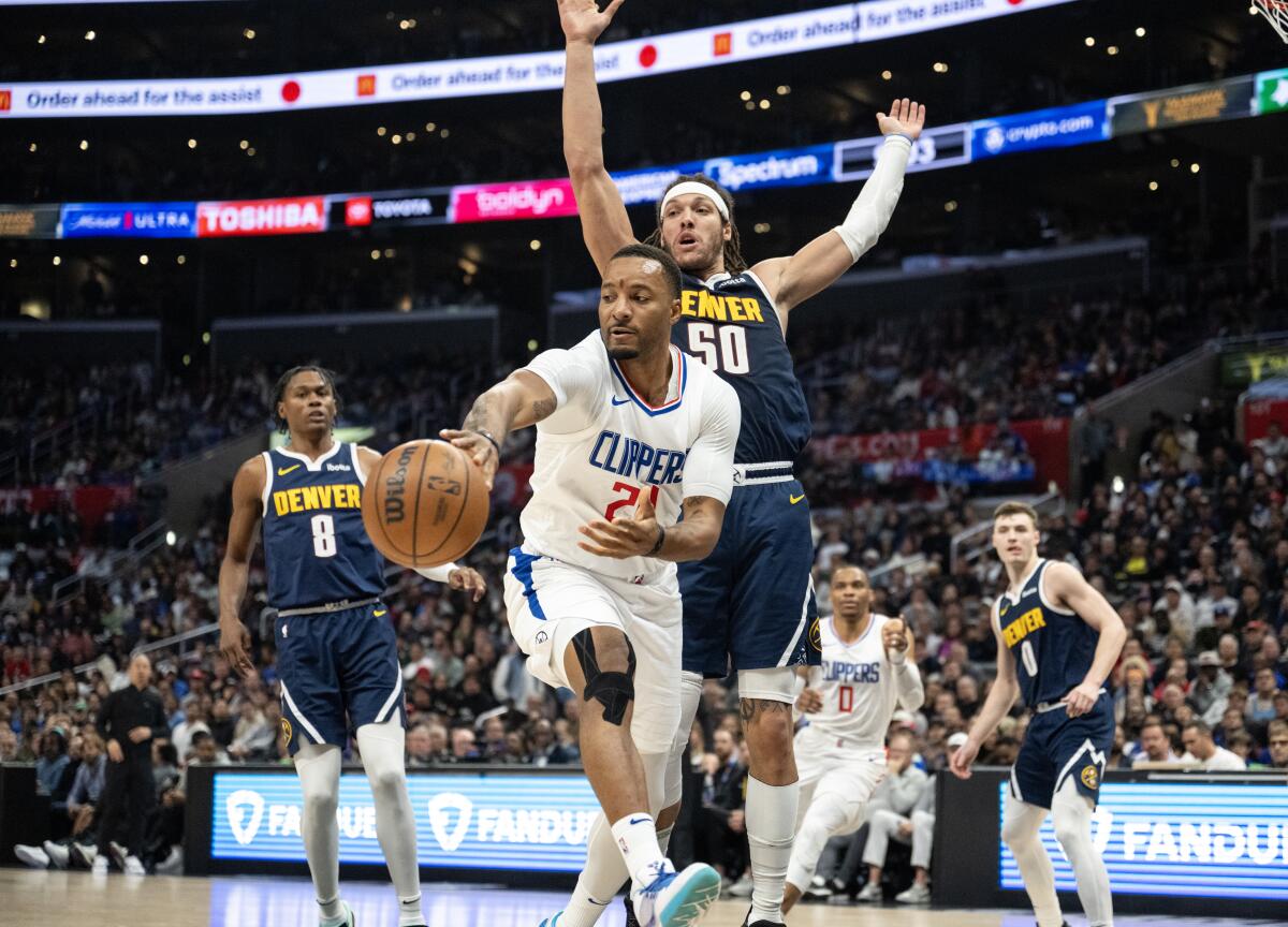 Clippers guard Norman Powell passes in front of Nuggets forward Aaron Gordon in the second half.