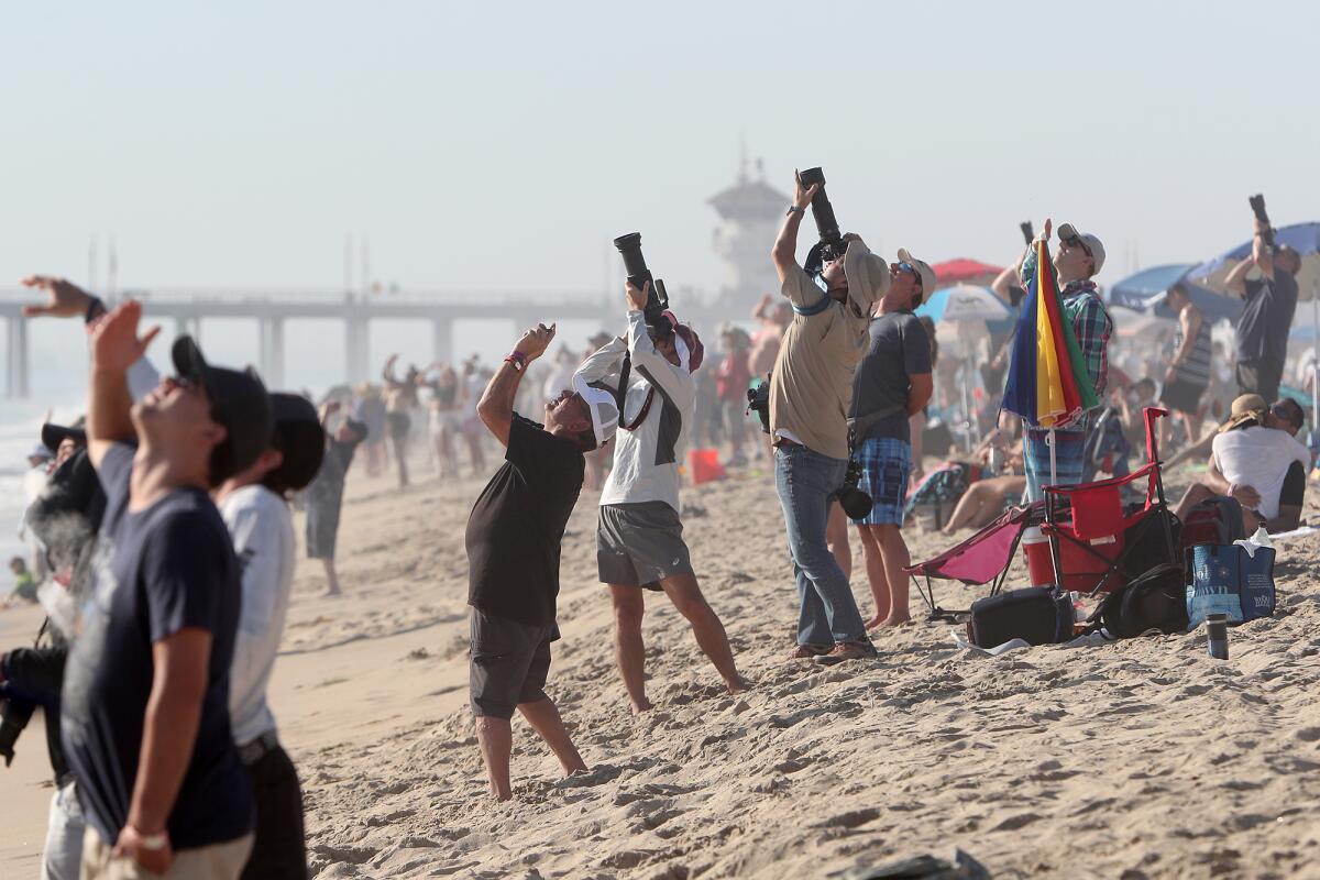 Visitors look to the sky as they watch the Pacific Airshow on Friday in Huntington Beach.