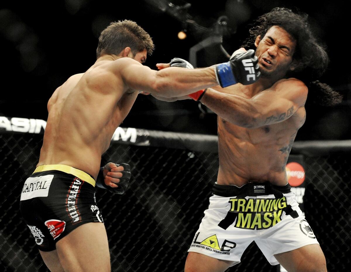 Josh Thomson, left, and Benson Henderson trade punches during their UFC lightweight bout on Saturday night in Chicago.