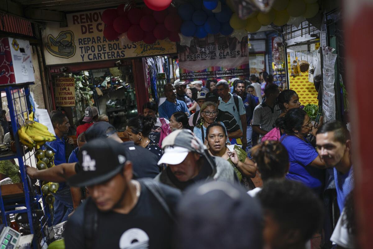 ARCHIVO - Gente comprando en un mercado callejero en el vecindario de Petare, en Caracas, Venezuela.